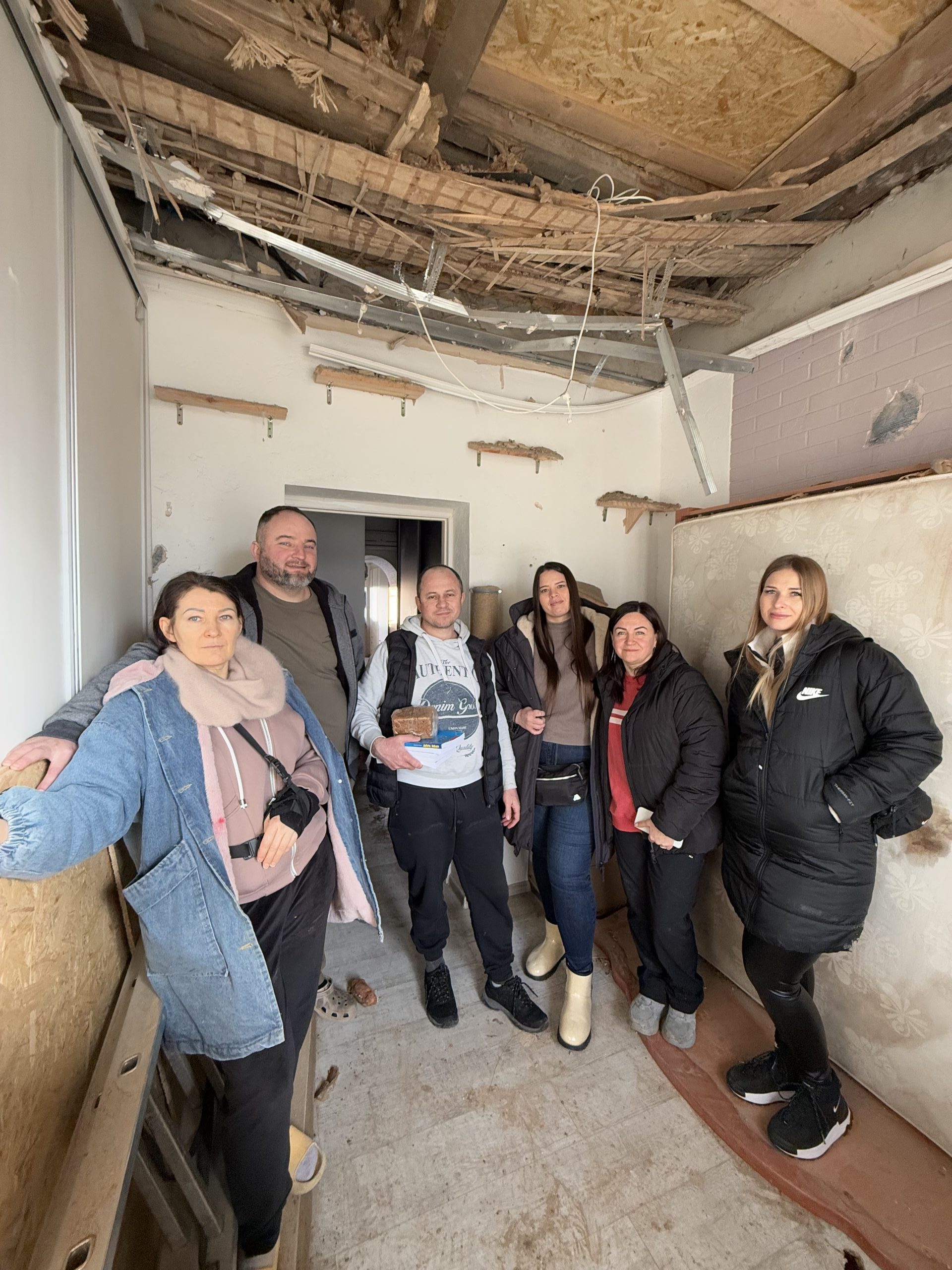 IMG_3065 Woman smiling in storage room with boxes and plastic bins.